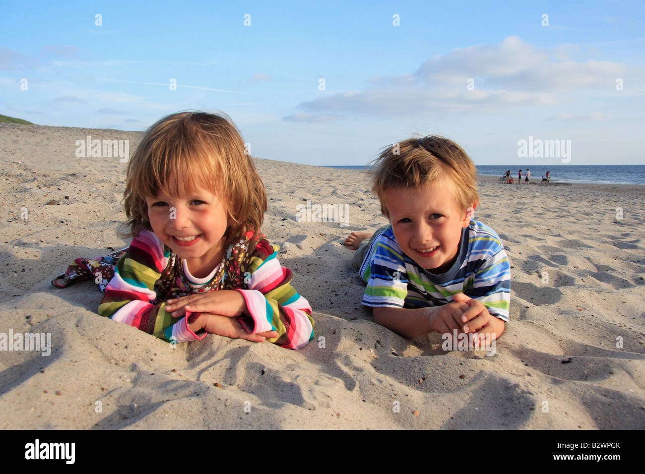 Mädchen und jungen im Sand am Strand liegen Stockfotografie Alamy