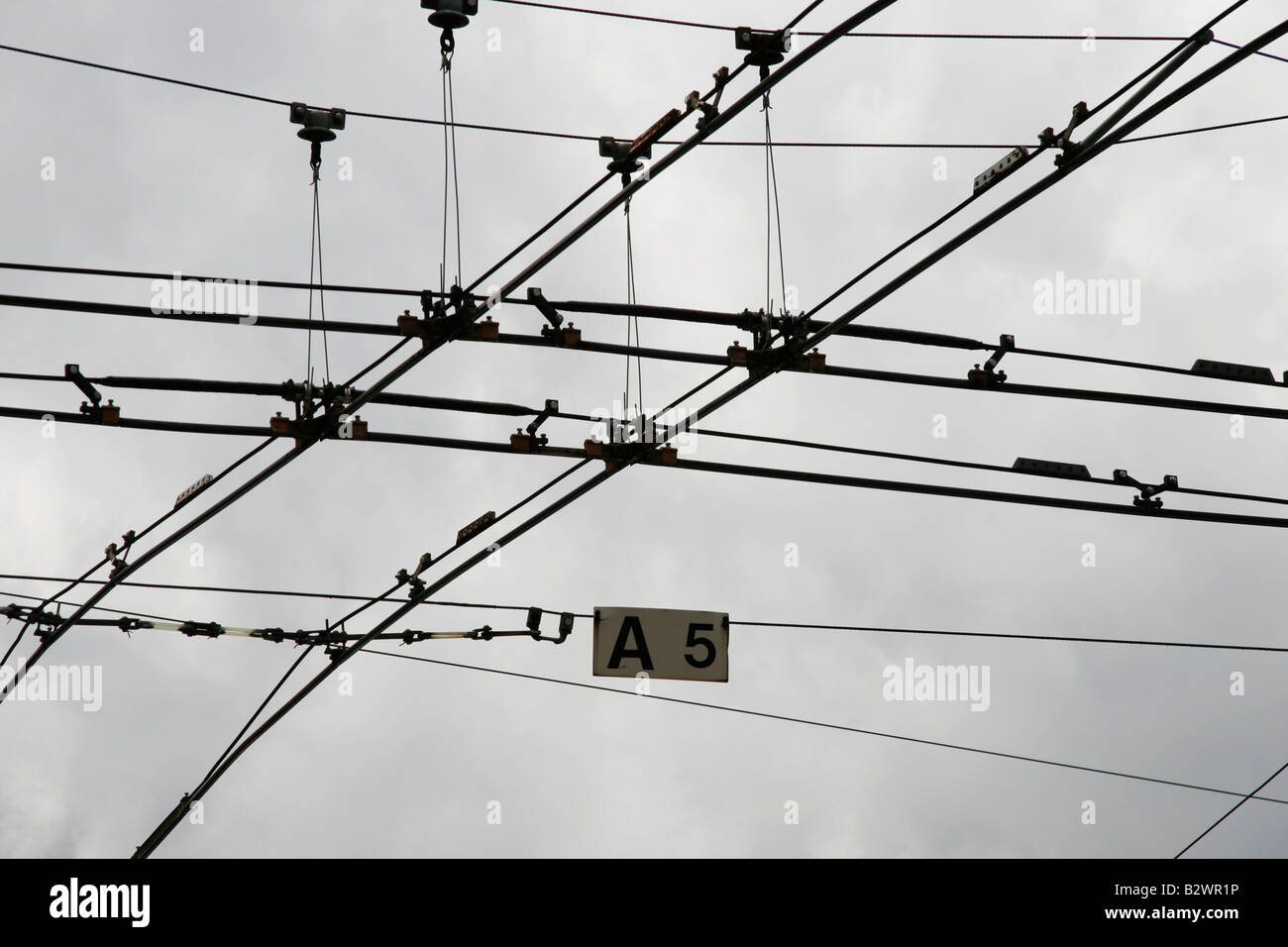 Obenliegende Straßenbahn Drähte kreuzen an einer belebten Kreuzung in Luzern, Zentralschweiz Stockfoto