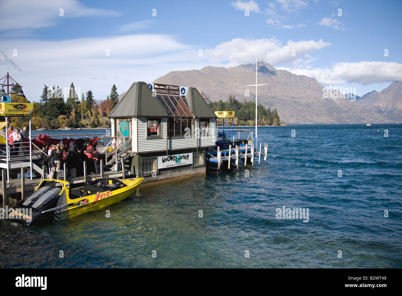 Leute warten auf das Jetboot am Kai am See wakatipu, Queenstown, Neuseeland Stockfoto