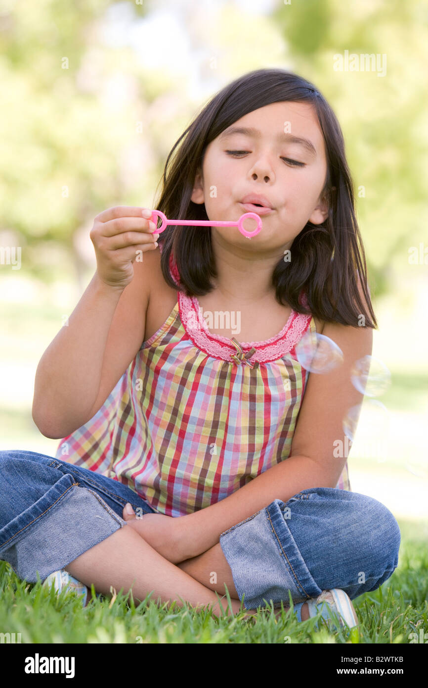 Junge Mädchen bläst Seifenblasen im Freien Stockfoto