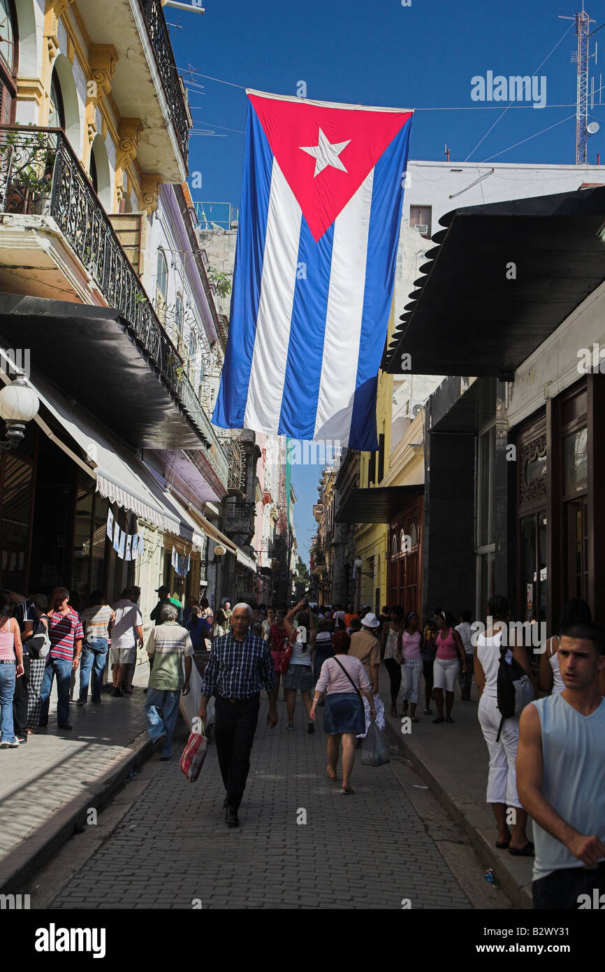 Menschen, die auf einer Straße in Havanna, Kuba unter der Nationalflagge Kubas Stockfoto