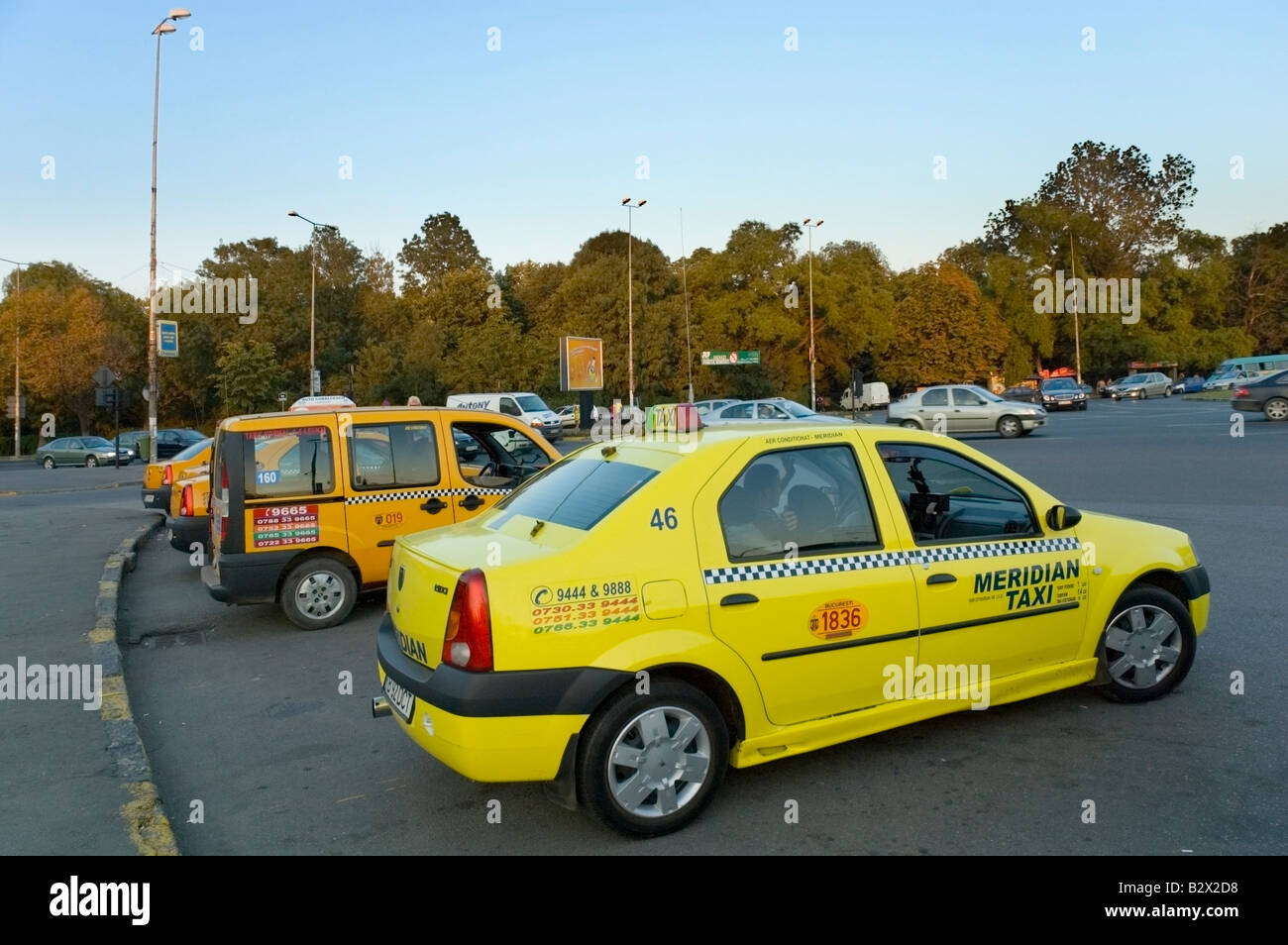 Bukarest-gelbe Taxis am quadratischen freie Presse gesäumt von Bäumen in herbstlichen Farben, Bukarest, Rumänien, Europa, EU Stockfoto