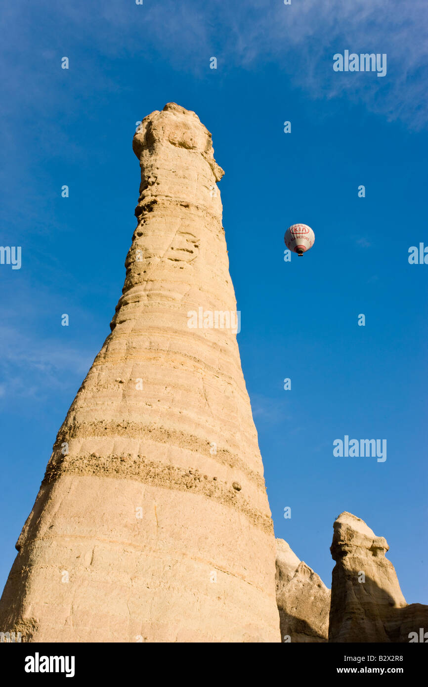 Heißluft-Ballon über die phallischen Säulen bekannt als Feenkamine im Tal bekannt als Liebe Tal in der Nähe von Göreme, Cappadocia Stockfoto