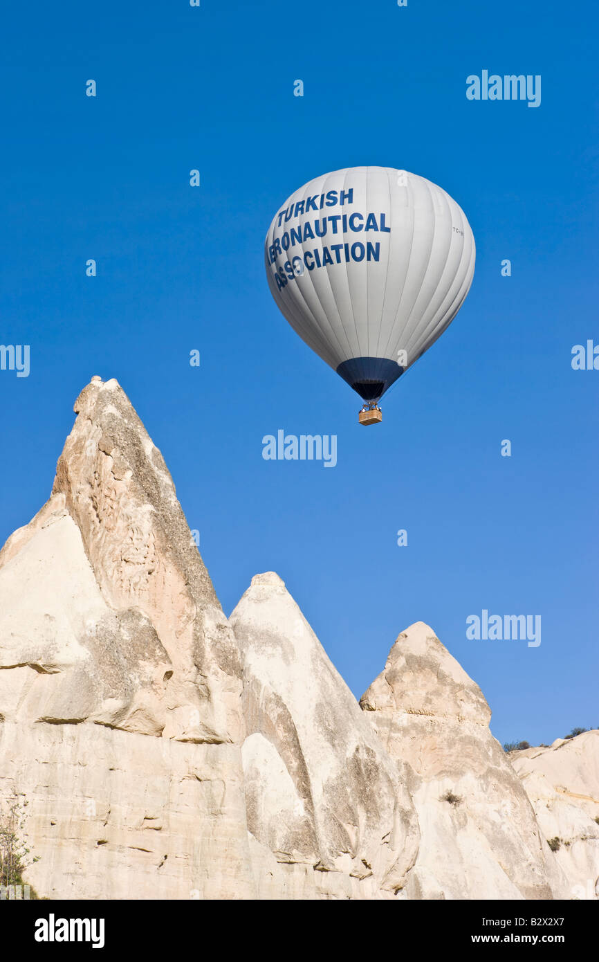 Heißluft-Ballon über die phallischen Säulen bekannt als Feenkamine im Tal bekannt als Liebe Tal in der Nähe von Göreme, Cappadocia Stockfoto