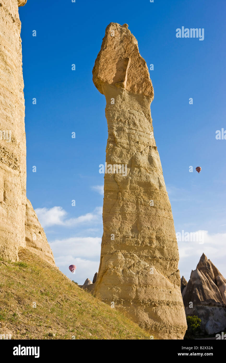 Heißluft-Ballon über die phallischen Säulen bekannt als Feenkamine im Tal bekannt als Liebe Tal in der Nähe von Göreme, Cappadocia Stockfoto