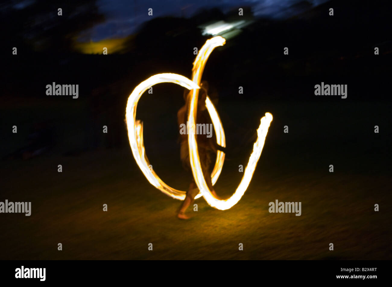 Ein Mädchen macht Feuer Kreise in einem Park. Stockfoto