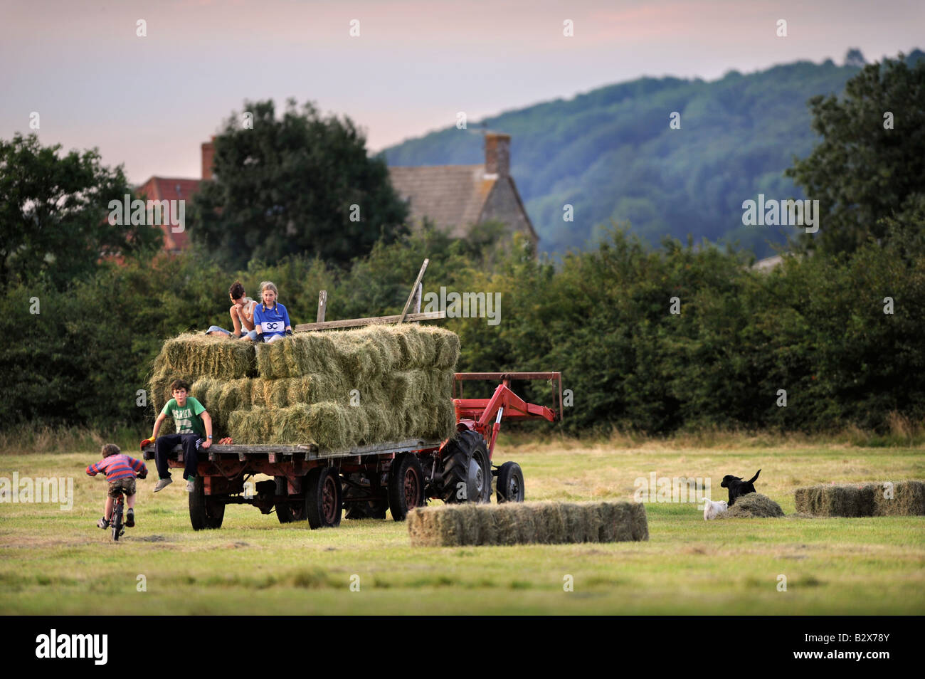 EINE BAUERNFAMILIE SAMMELN HEU IM TRADITIONELLEN STIL IN GLOUCESTERSHIRE UK Stockfoto