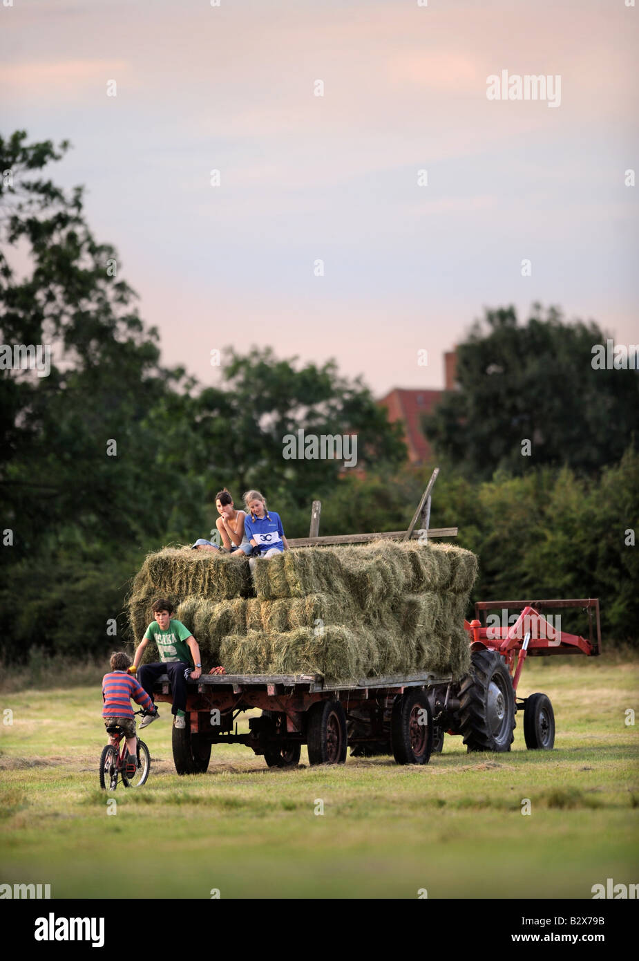 EINE BAUERNFAMILIE SAMMELN HEU IM TRADITIONELLEN STIL IN GLOUCESTERSHIRE UK Stockfoto