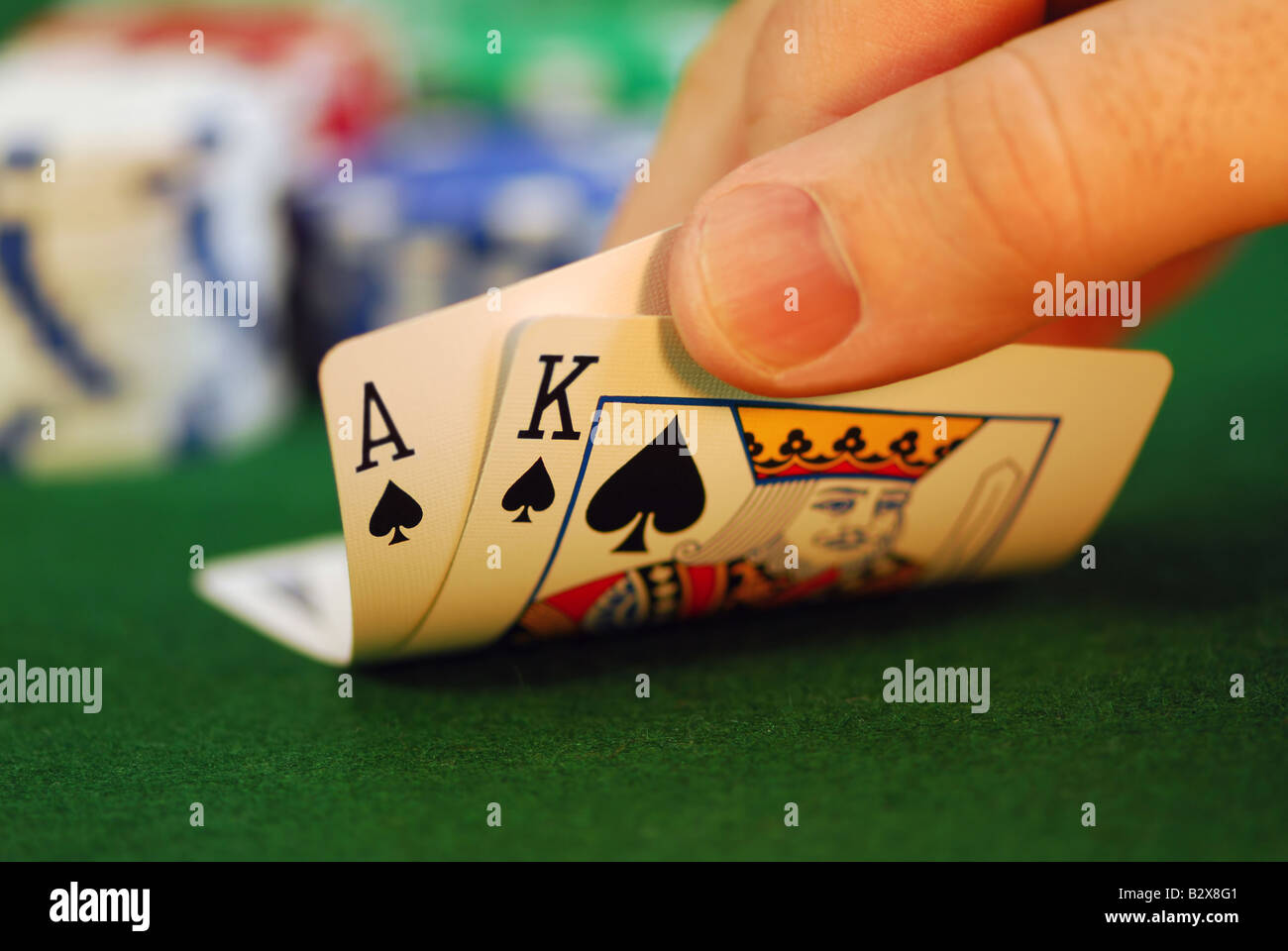 Mann die Hand heben Sie Spielkarten an einem Pokertisch Stockfoto