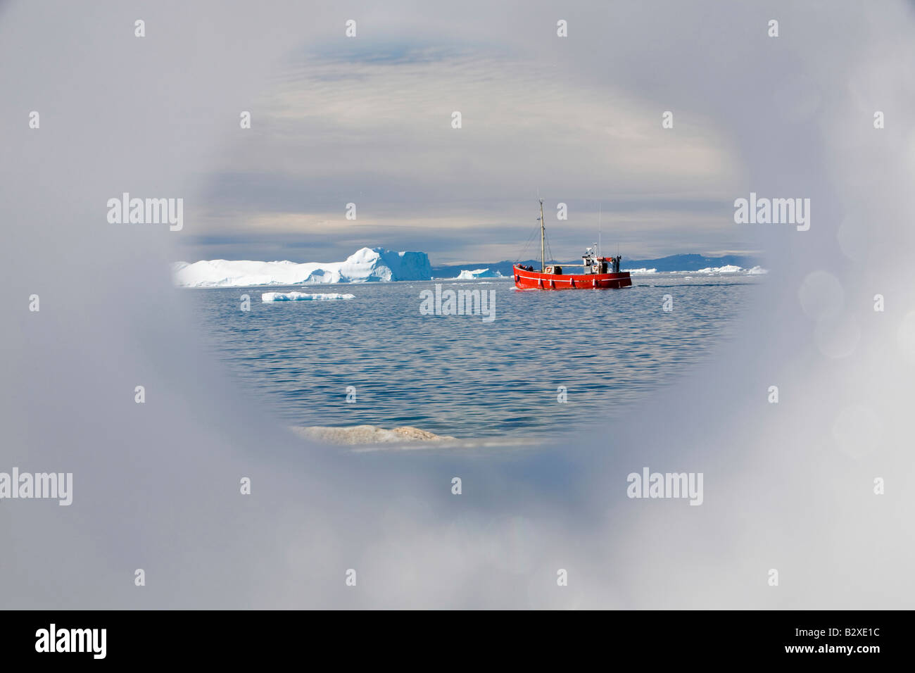 Ein Fischerboot verlassen Ilulissat auf Grönland durch einen Eisberg fotografiert Stockfoto