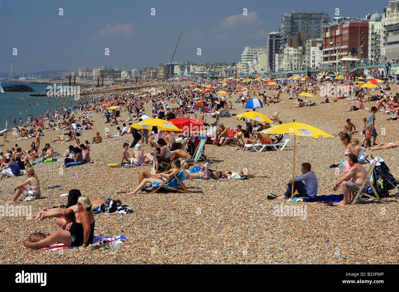 Menschen entspannen am Brighton Strand an einem sonnigen Sommertag Stockfoto