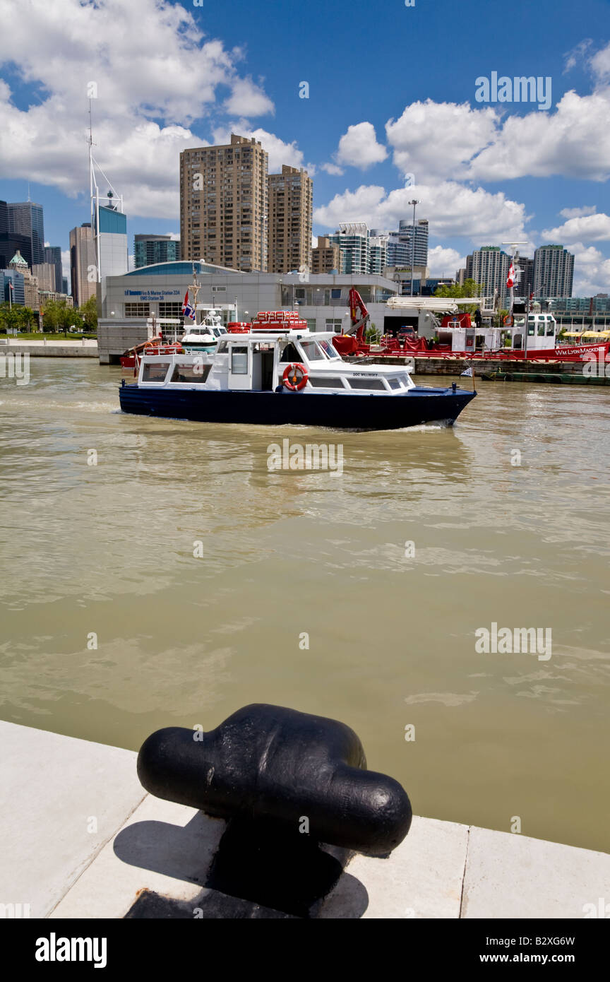 Ein kleines Boot geht über das Feuer und Marine Station 334 und EMS Station 36 Queens Quay West, Toronto, Kanada. Stockfoto