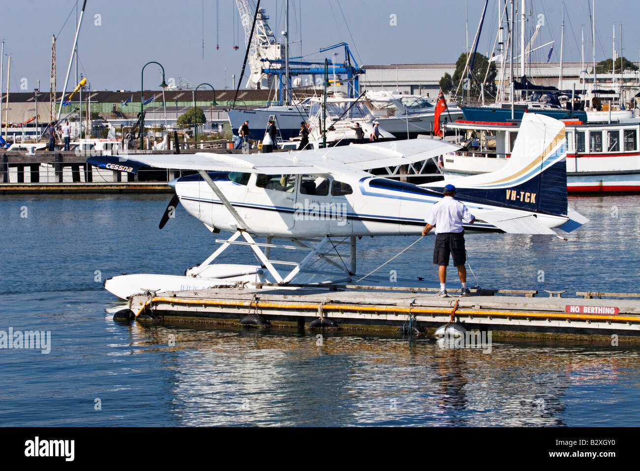 Malerischen Melbourne / A Wasserflugzeug Pilot sein Flugzeug in Williamstown, Melbourne Australien sichert. Stockfoto