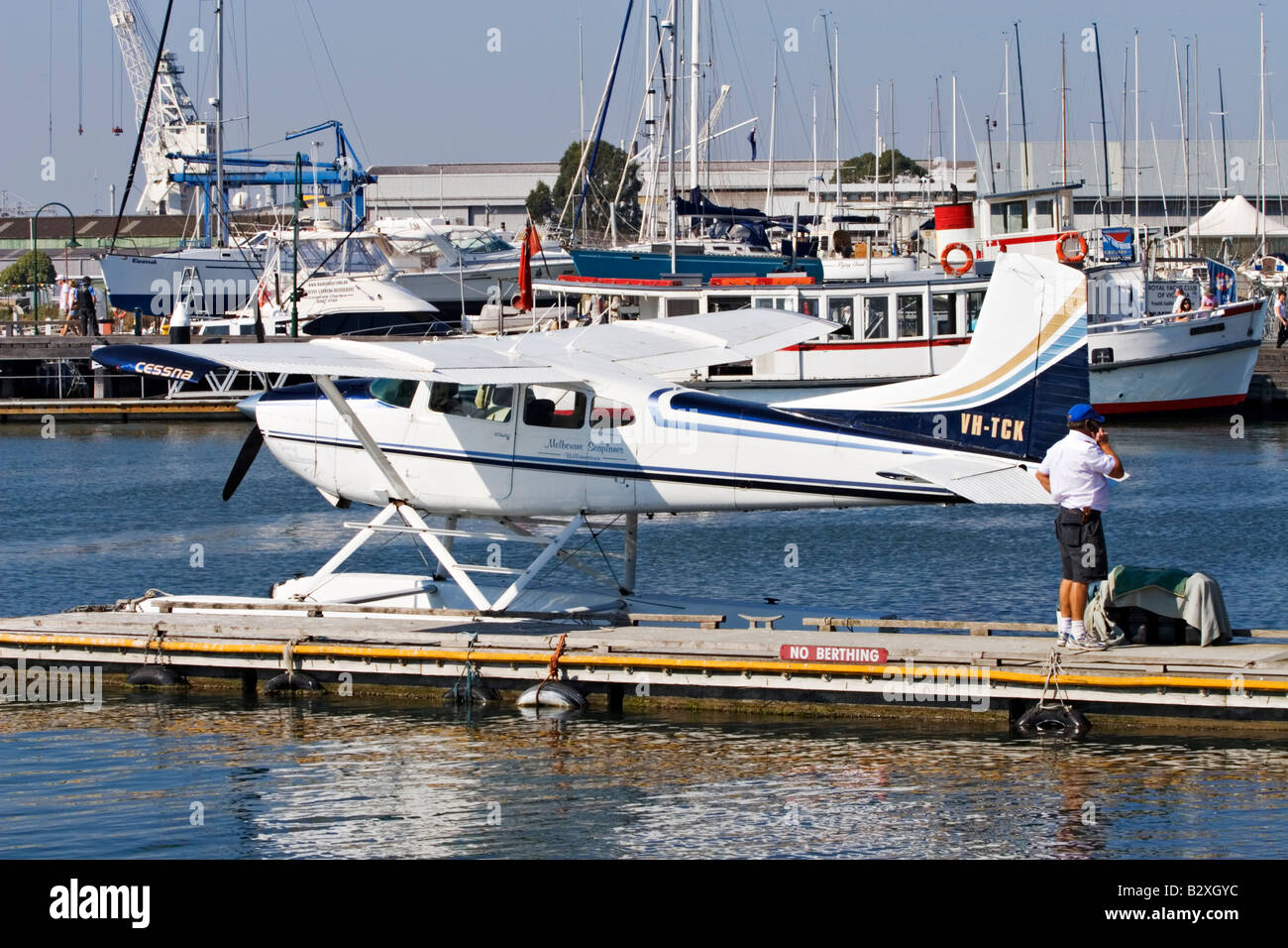 Malerischen Melbourne / A Wasserflugzeug Pilot spricht über sein Handy neben seinem Flugzeug in Williamstown, Melbourne Australien. Stockfoto