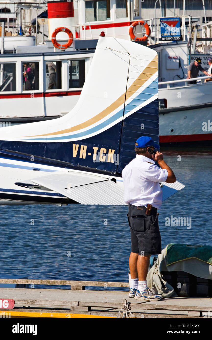 Malerischen Melbourne / A Wasserflugzeug Pilot spricht über sein Handy neben seinem Flugzeug in Williamstown, Melbourne Australien. Stockfoto
