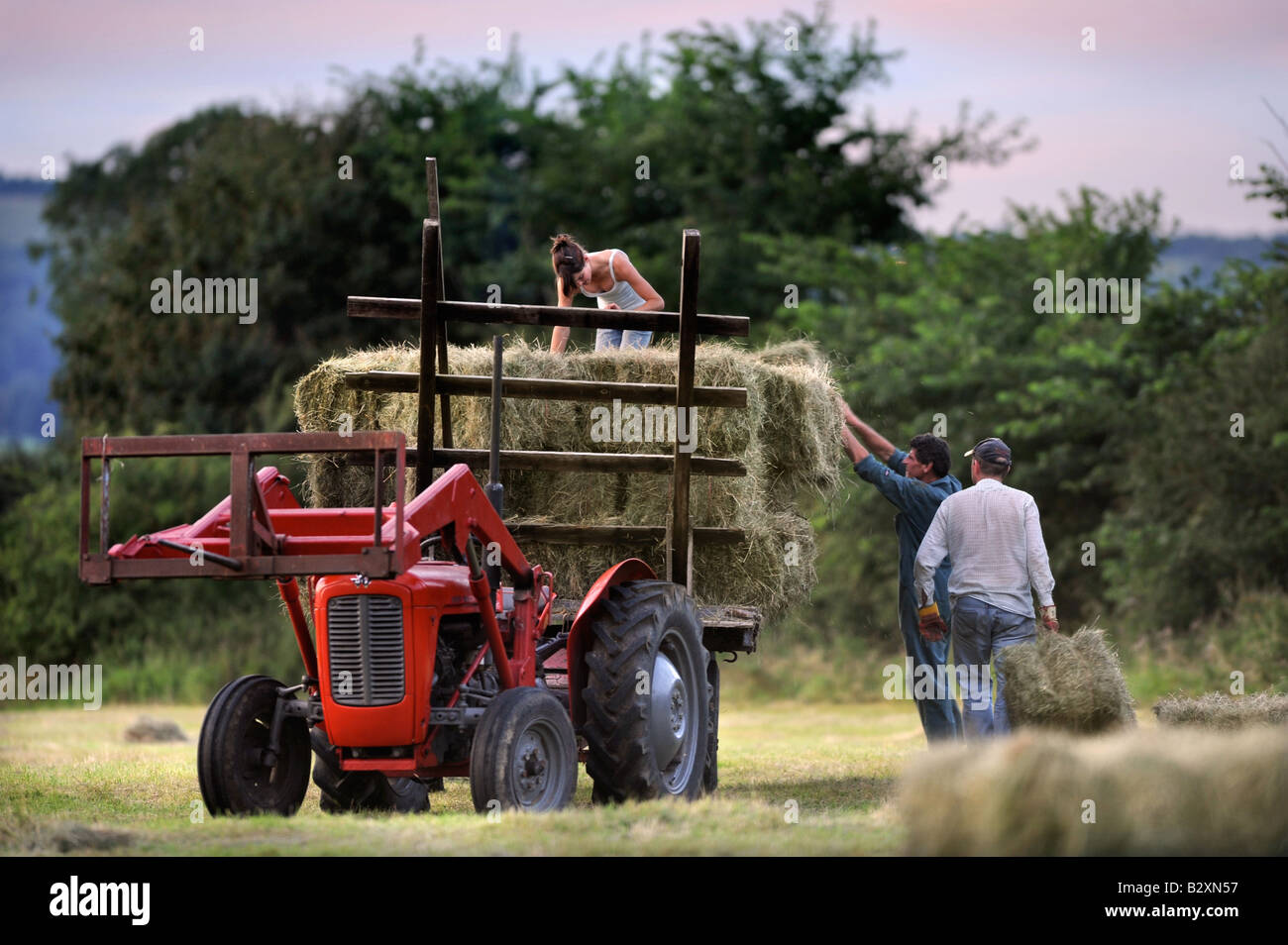 EINE BAUERNFAMILIE SAMMELN HEU IM TRADITIONELLEN STIL IN GLOUCESTERSHIRE UK Stockfoto