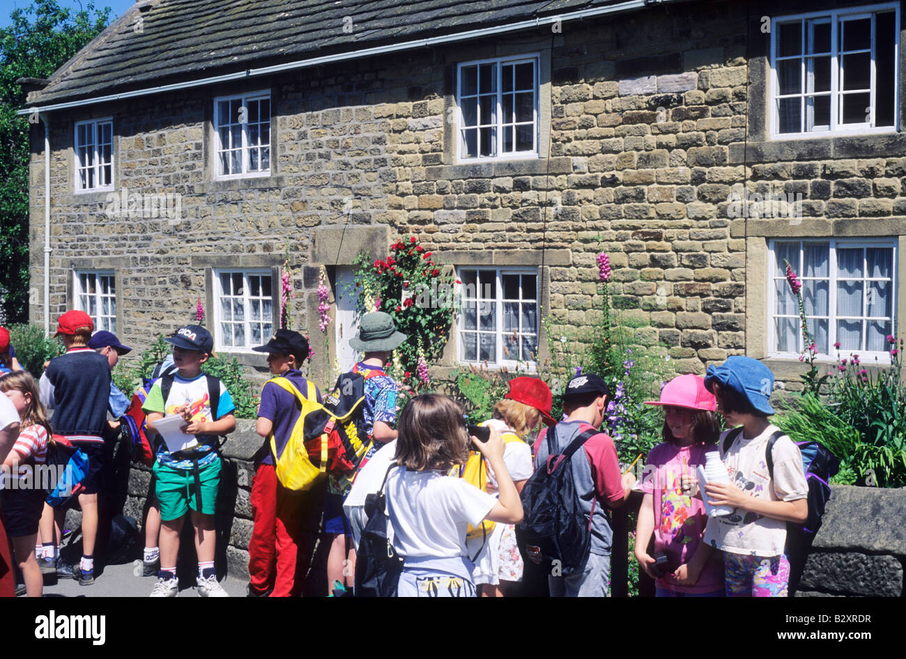 Kinder besuchen Pest Cottages Eyam Derbyshire leuchtend bunte Kleidung große Pest 1665 England UK Besucher Stockfoto