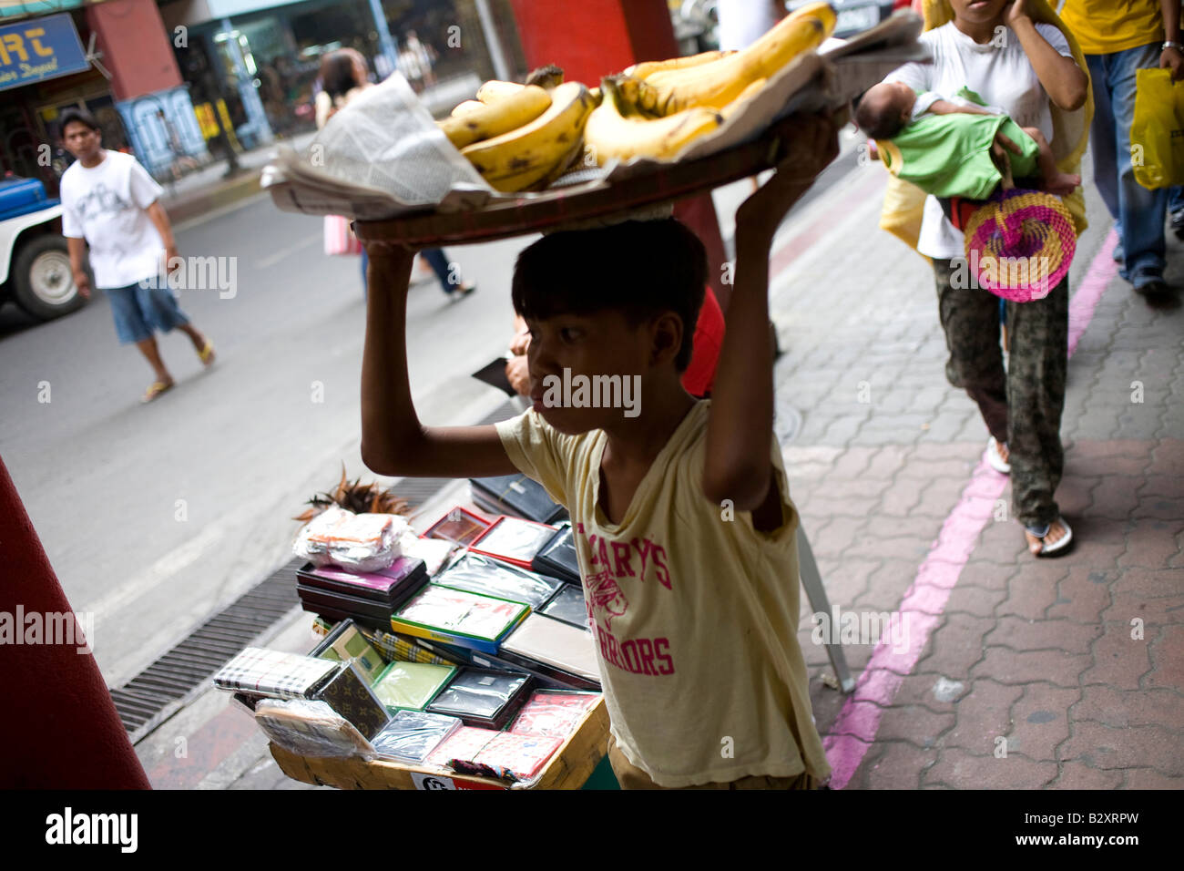 Ein Filipino junge ist eine Zuladung von frischen Bananen in Manila, Philippinen. Stockfoto