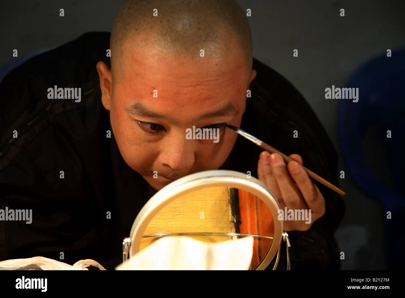 ein Künstler malt sein Gesicht in Reihenfolge für die Ausführung der Sichuan-Oper in Chengdu, China Stockfoto