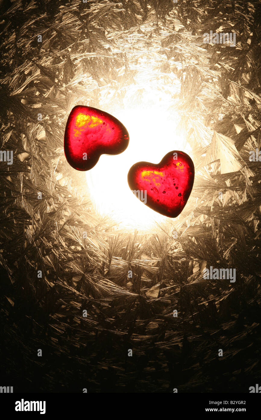 zwei rote Herzen Glühen auf eine mattierte Oberfläche Stockfoto