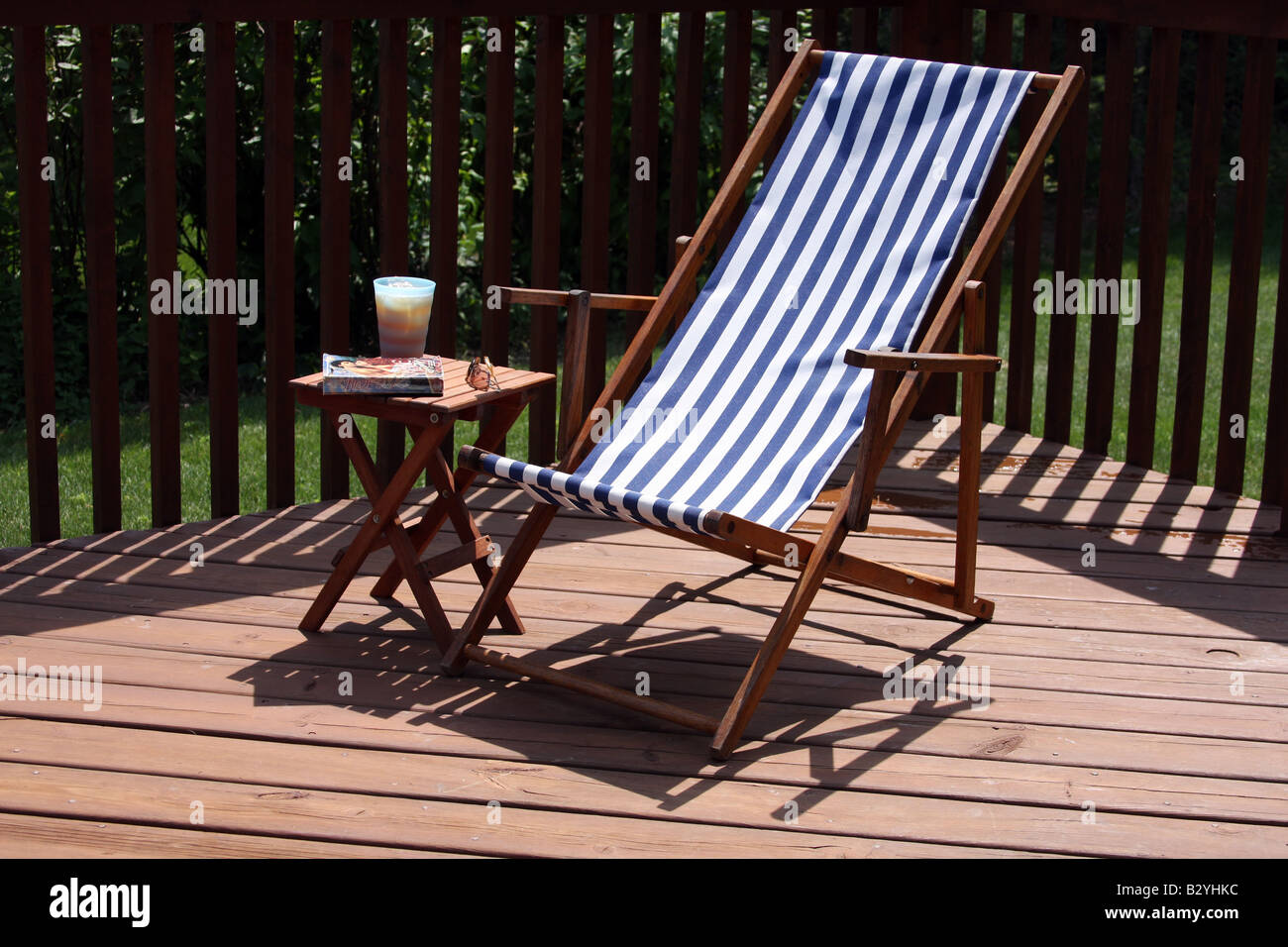Entspannen und lesen auf der Terrasse im Sommer mit Eistee und einen Liebesroman Stockfoto
