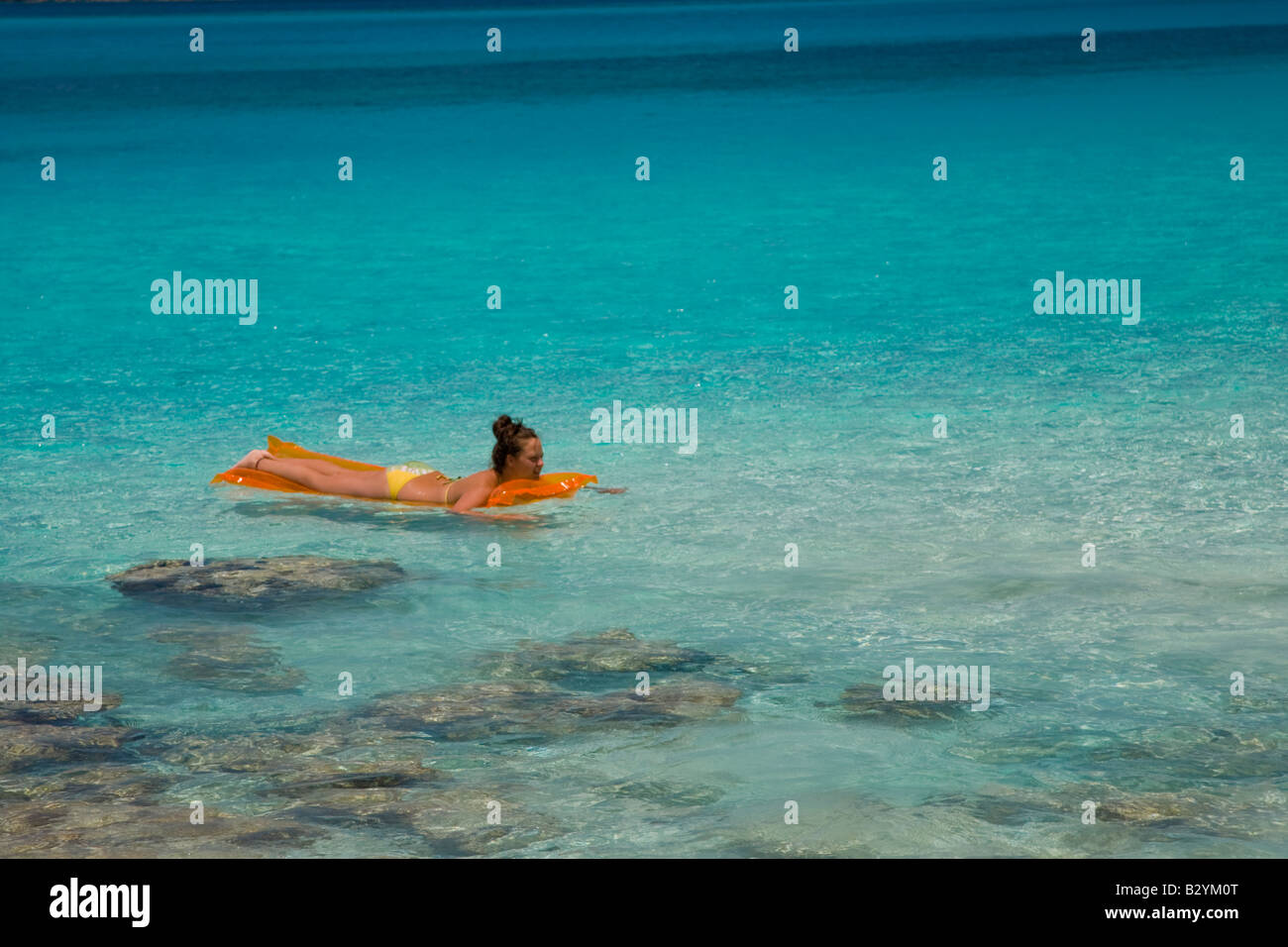 Frau schwimmt auf Luftmatratze im Cinnamon Bay in Virgin Islands Nationalpark auf der karibischen Insel St. John in den USA Stockfoto