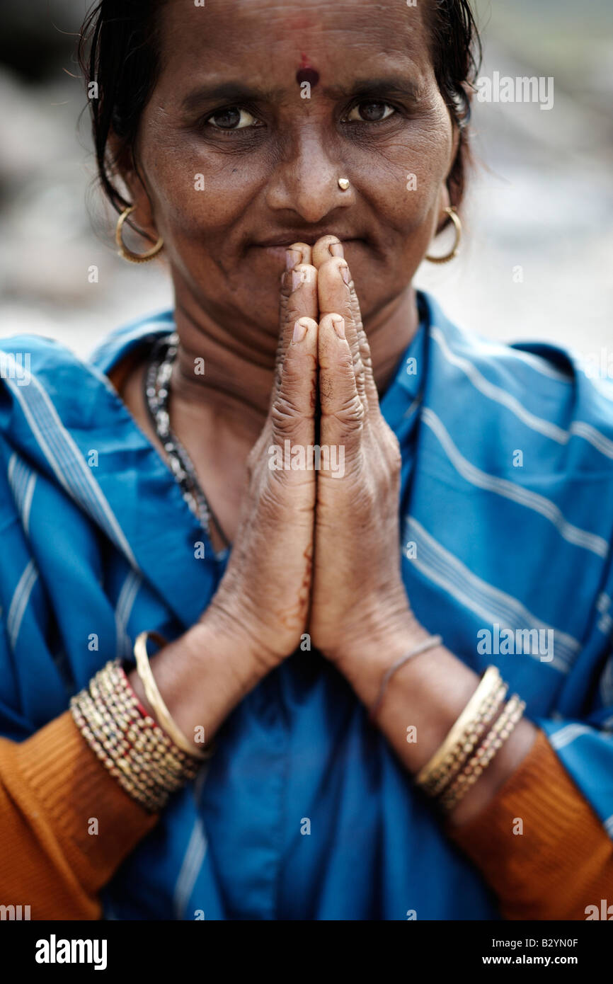 Ein Hindu, hält indische Frau trägt einen bunten Sari und dekorativen Schmuck ihre Hände zusammen in einem Gebet. Stockfoto
