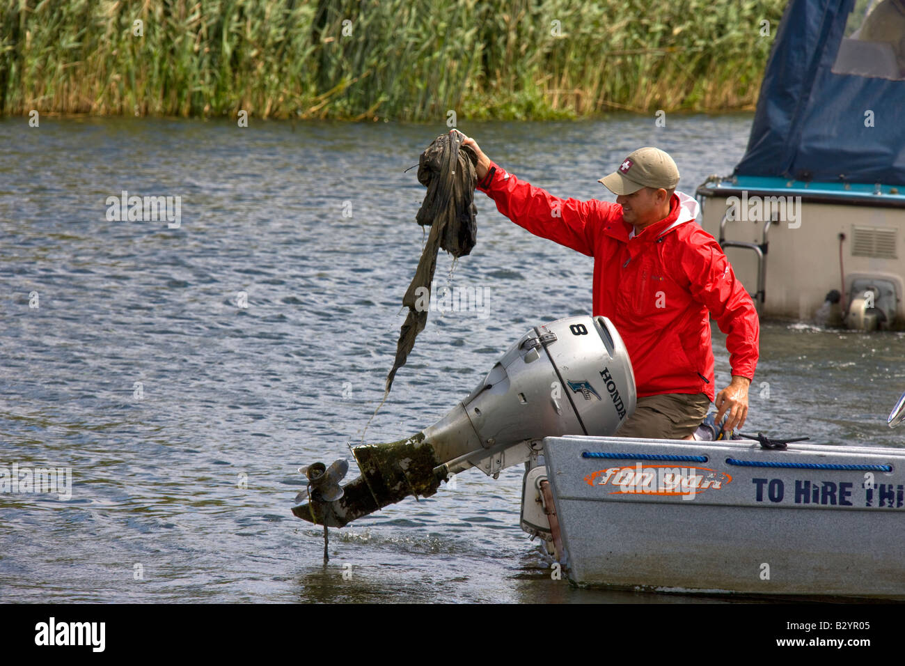 Clearing des Propellers das Boot Außenborder von Müll, die der Motor funktioniert nicht mehr hatte. Stockfoto