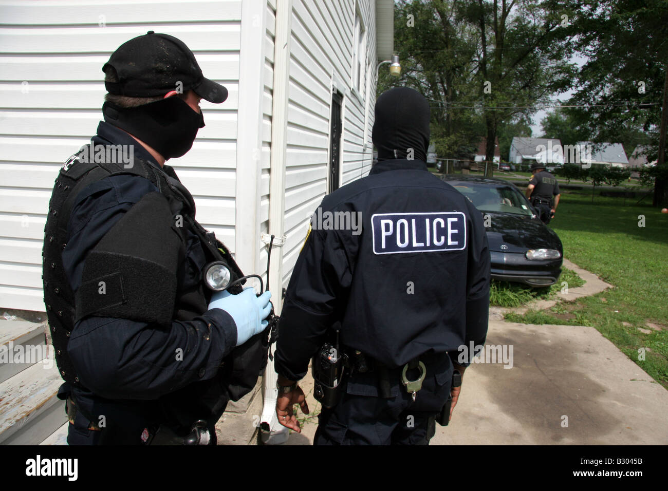 Polizisten aus Detroit Drogen suchen, ein Auto und den Hinterhof eines Hauses für Medikamente Stockfoto
