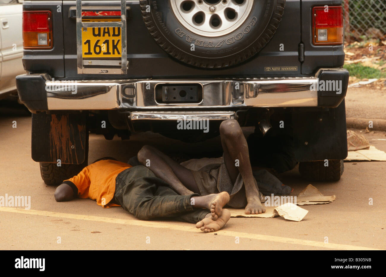 Homeless Street Kinder unter geparkten Auto schlafen. Kampala, Uganda. Stockfoto