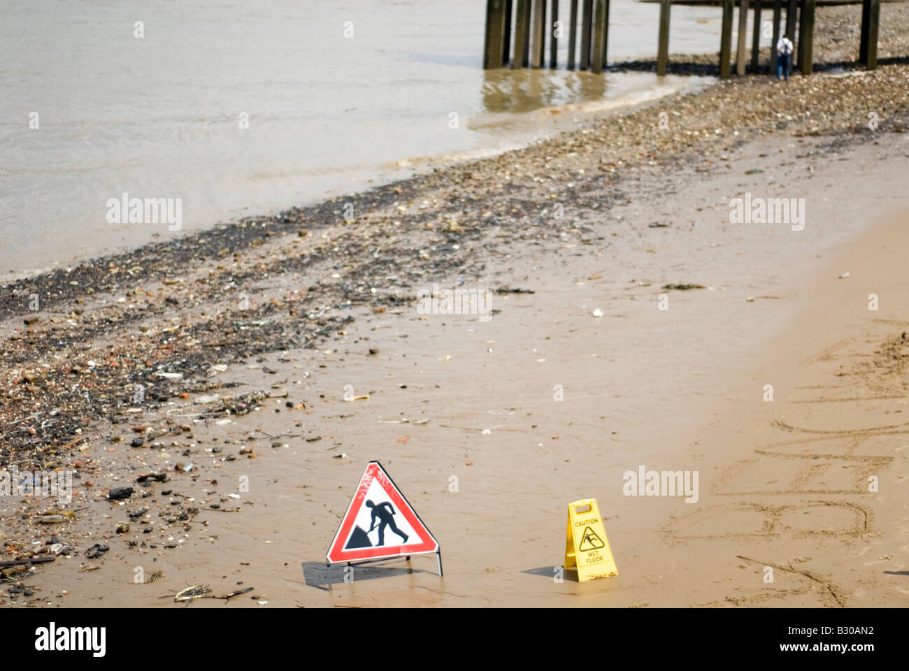 Arbeit Zeichen auf nassen Strand am Fluss Themse Stockfoto