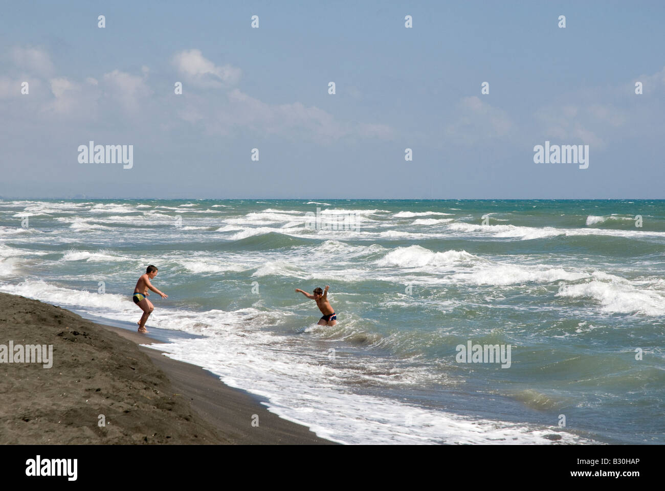 Zwei Jungen spielen in den Wellen im Badeort von Montalto di Marina am Mittelmeer Stockfoto
