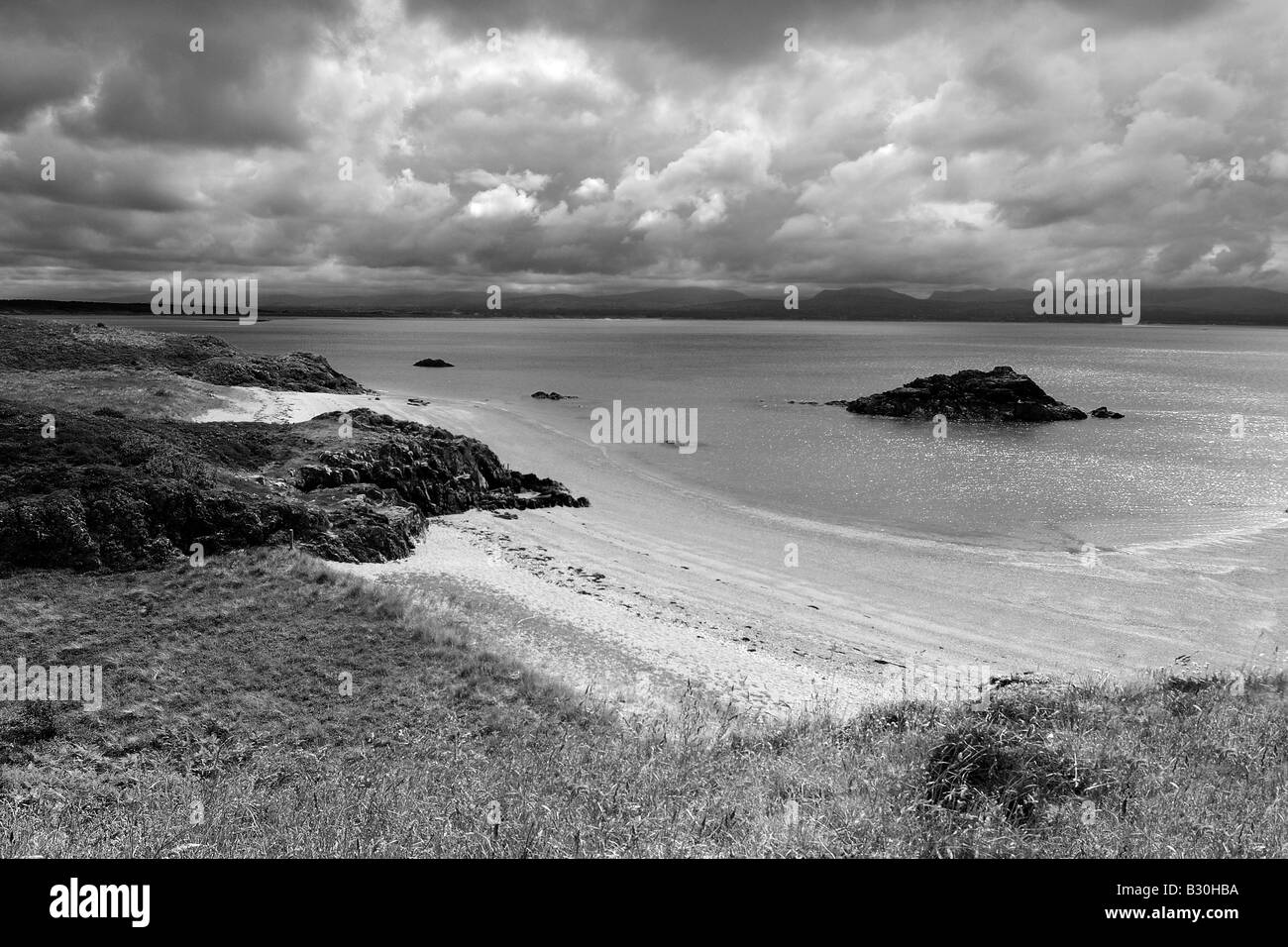 Porth Y Clochydd auf Llanddwyn Island vor der Küste von Anglesey in Newborough Warren in schwarz / weiß Stockfoto