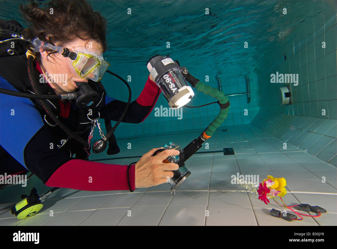 Frau Taucher Praktiken Unterwasserfotografie im Schwimmbad Stockfoto