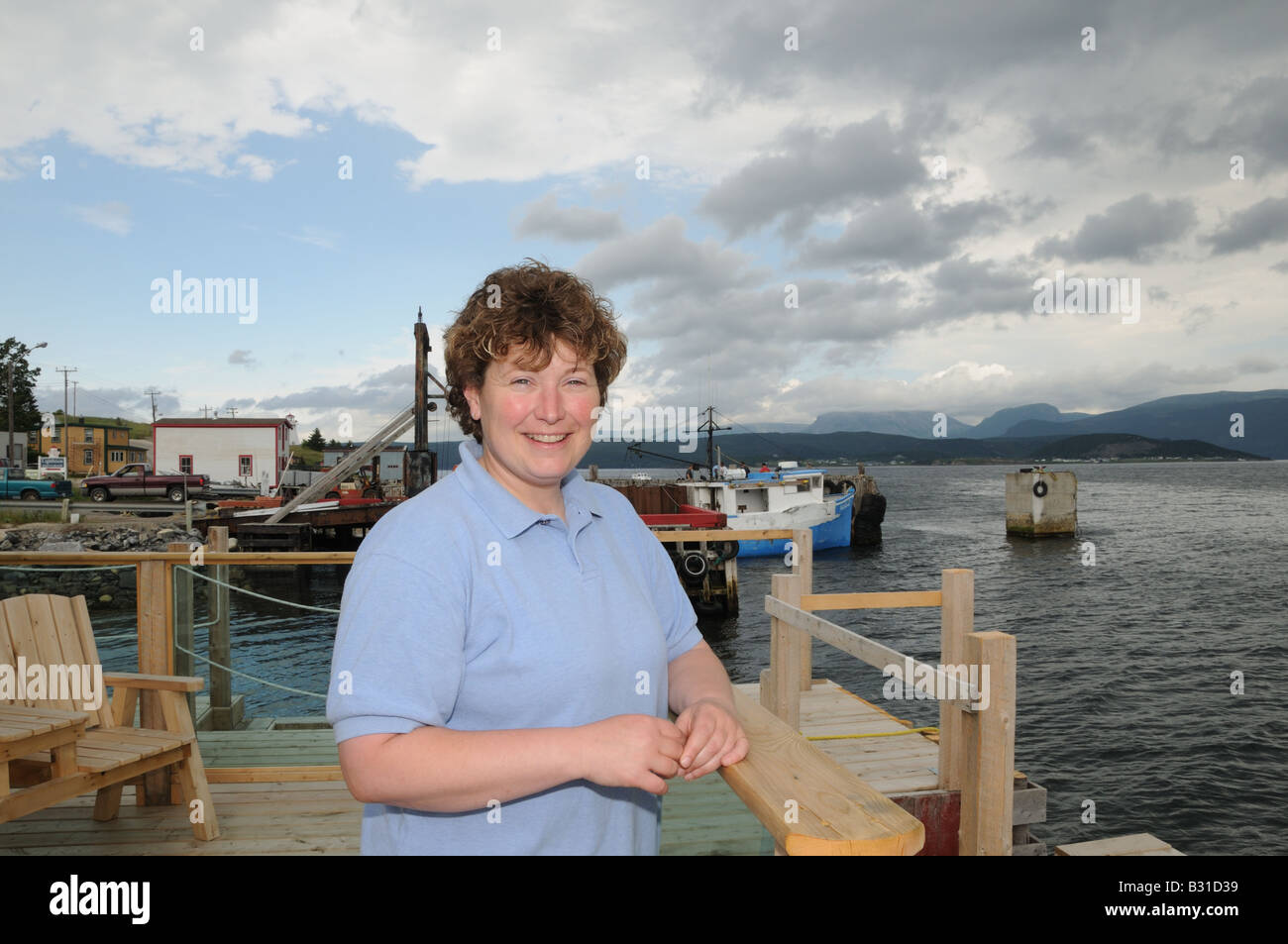 Darlene Thomas stehend auf dem Deck des Seaside Suites in Woody Point, Neufundland, ein Fischerdorf an der Bucht von Bonne. Stockfoto