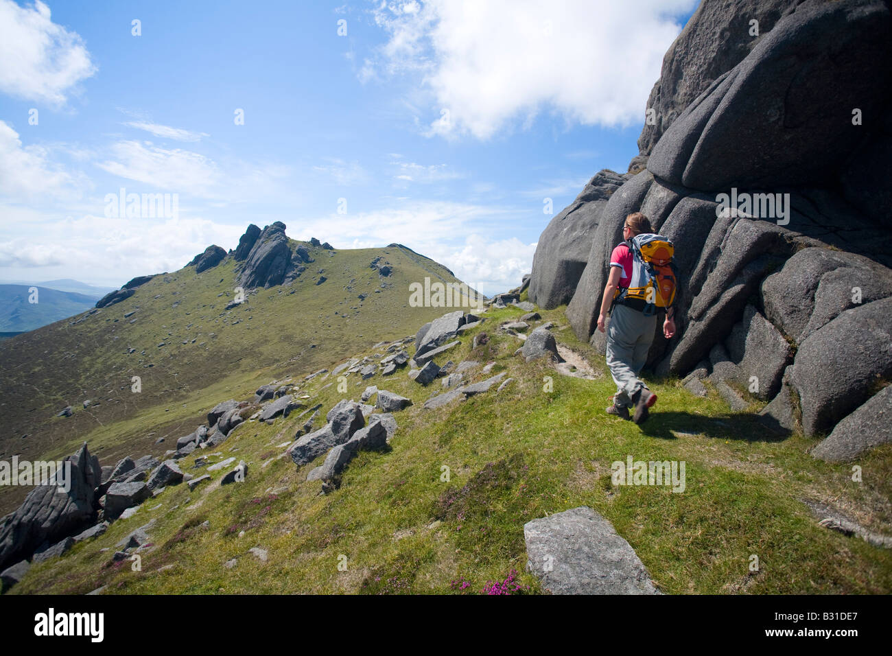 Walker vorbei an der Nord Tor der Slieve Bearnagh, Mourne Mountains, County Down, Nordirland, Großbritannien. Stockfoto