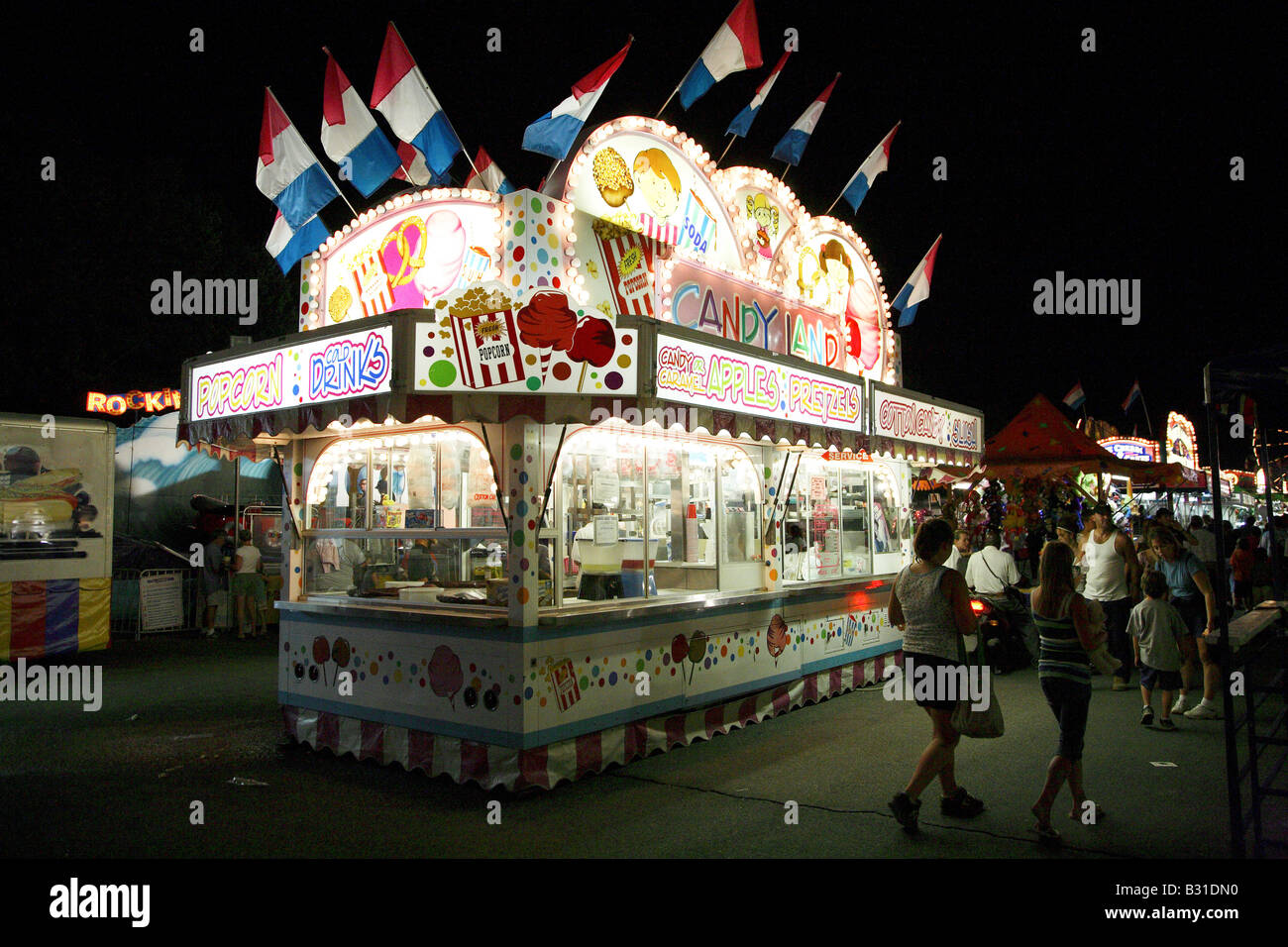 Garküche ist nachts beleuchtet. Verkauf von Popcorn und Süßigkeiten Äpfel. Stockfoto