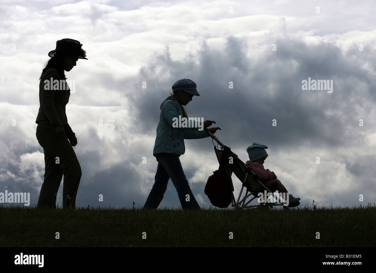 Silhouetten von einer Familie zu Fuß über ein Feld Stockfoto