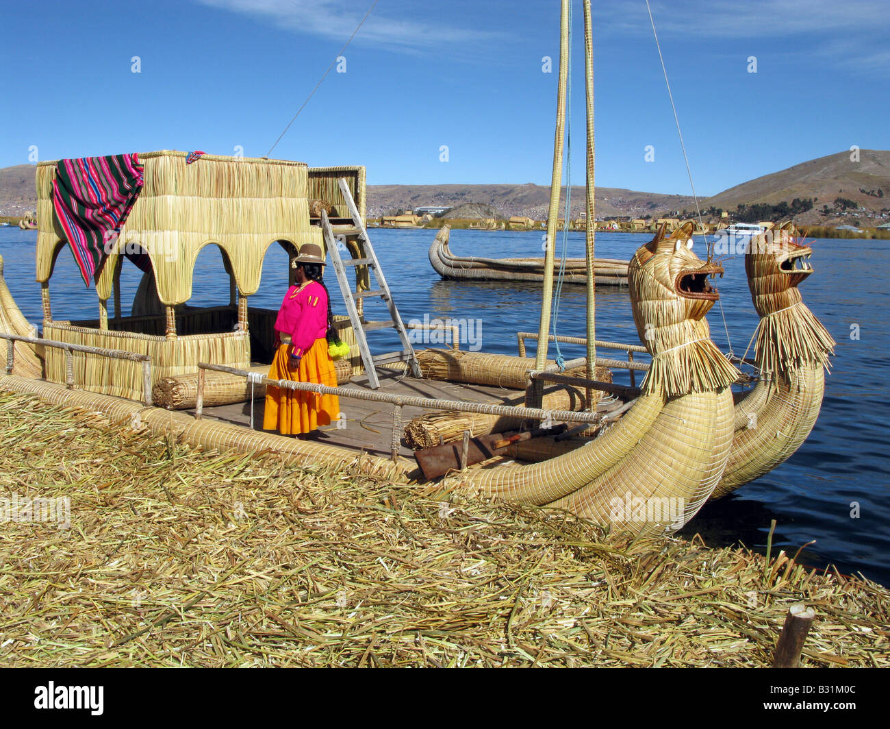 Ein Mitglied der Uros Menschen ein Ruderboot am Titicacasee, Peru, Südamerika Stockfoto