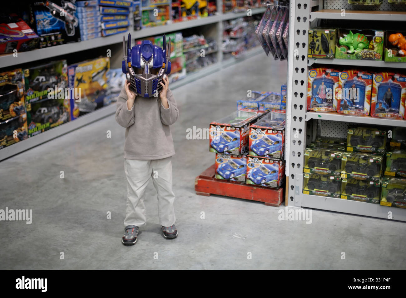 Sechs Jahre alter Junge in erstmals auf Optimus Prime Roboter Helm aus dem Spielberg-Film Transformers versucht Stockfoto
