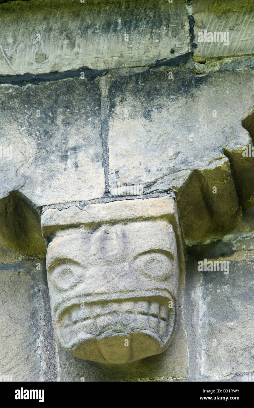 Detail der Corbel Fries aus Südwand geschnitzt von lokalen Mühlstein Korn mit grotesken Köpfe St. Johannes der Täufer Kirche Adel Stockfoto