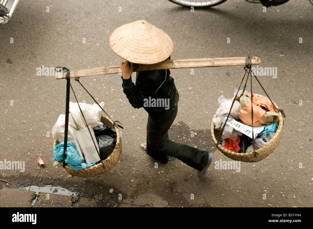 Ein Blick von oben von einem Straßenhändler tragen Körbe auf einem Schulter-Mast in Hanoi Vietnam ausgesetzt Stockfoto