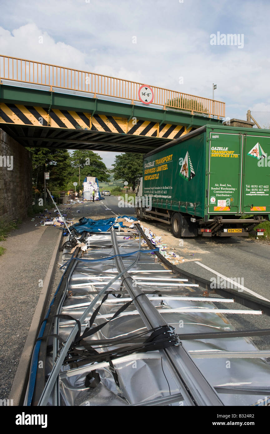 Gegliederte Wagen vorbei unter niedrigen Eisenbahnbrücke hat Dach des Anhängers abgerissen Kirkby Stephen Cumbria Stockfoto