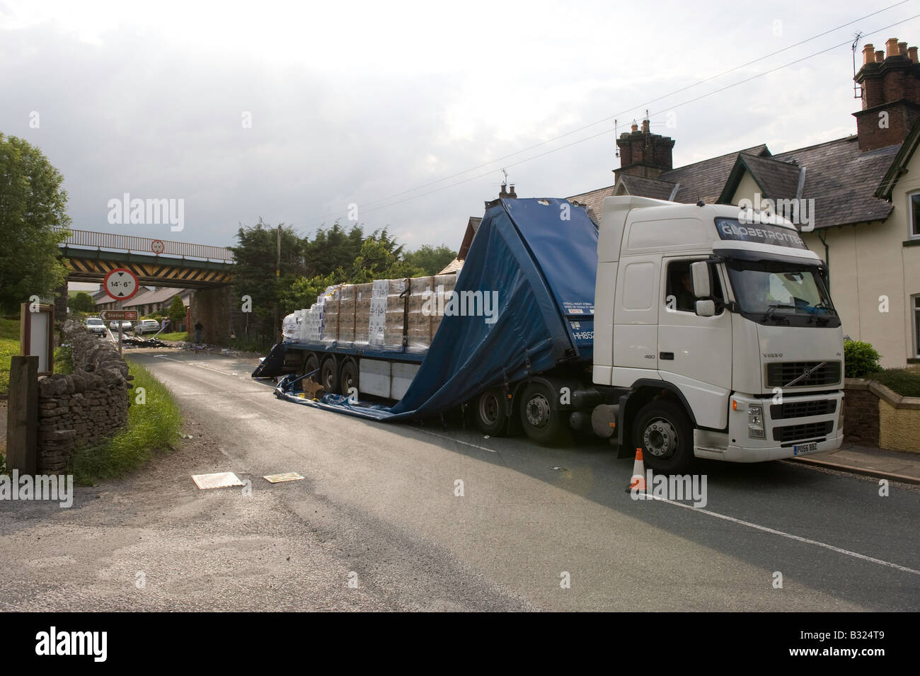 Gegliederte Wagen vorbei unter niedrigen Eisenbahnbrücke hat Dach des Anhängers abgerissen Kirkby Stephen Cumbria Stockfoto