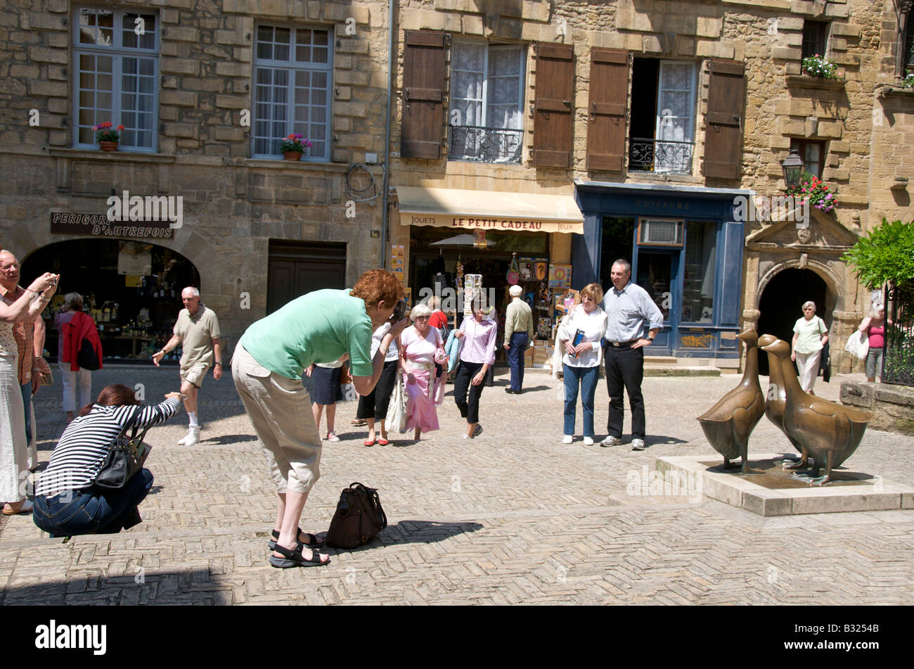 Platzieren Sie Aux Ojes / Gans Quadrat - Touristen fotografieren von Gänse-Statue in Sarlat la Caneda, Dordogne, Frankreich Stockfoto