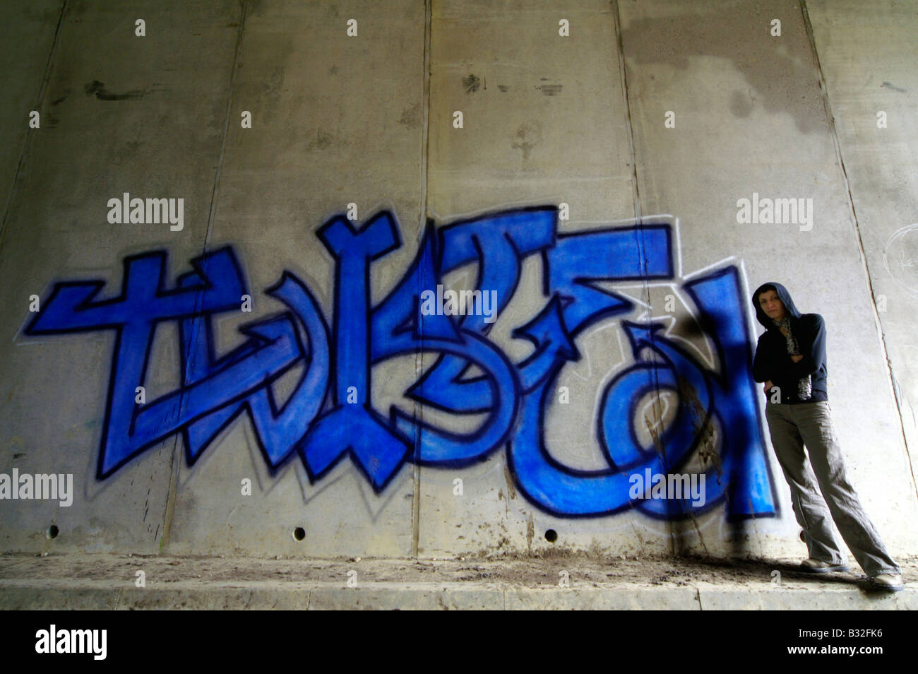 Mit Kapuze Mädchen neben ihr Graffiti an der Wand im Tunnel, South Bank, London Stockfoto