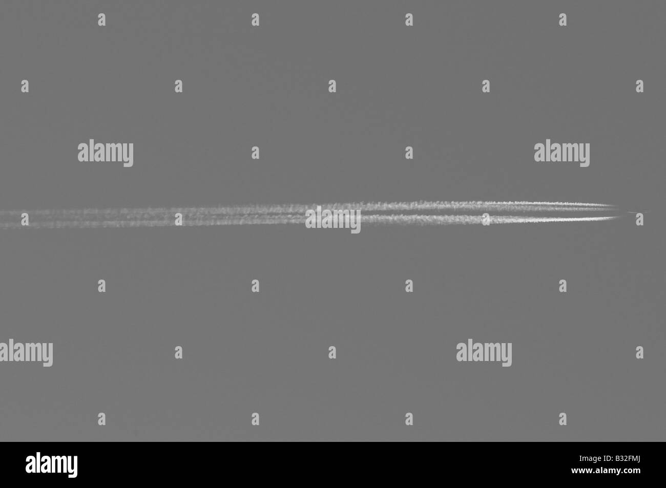 Ein Flugzeug Flugzeug fliegen hoch aufragenden hoch im Himmel hinterließ eine Schneise der Kondensation, Dampf in seinem Gefolge. Jemand geht auf Urlaub. Stockfoto