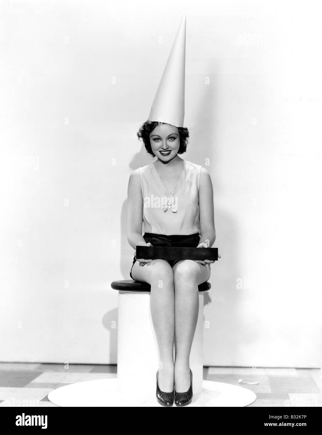 Porträt der Frau mit Aprilscherz Schild mit Dunce Mütze Stockfoto
