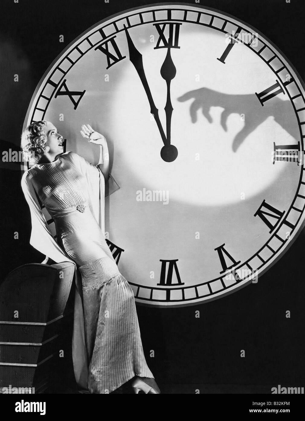 Frau mit großen Uhr Aufwickeln von erschreckend hand Stockfoto