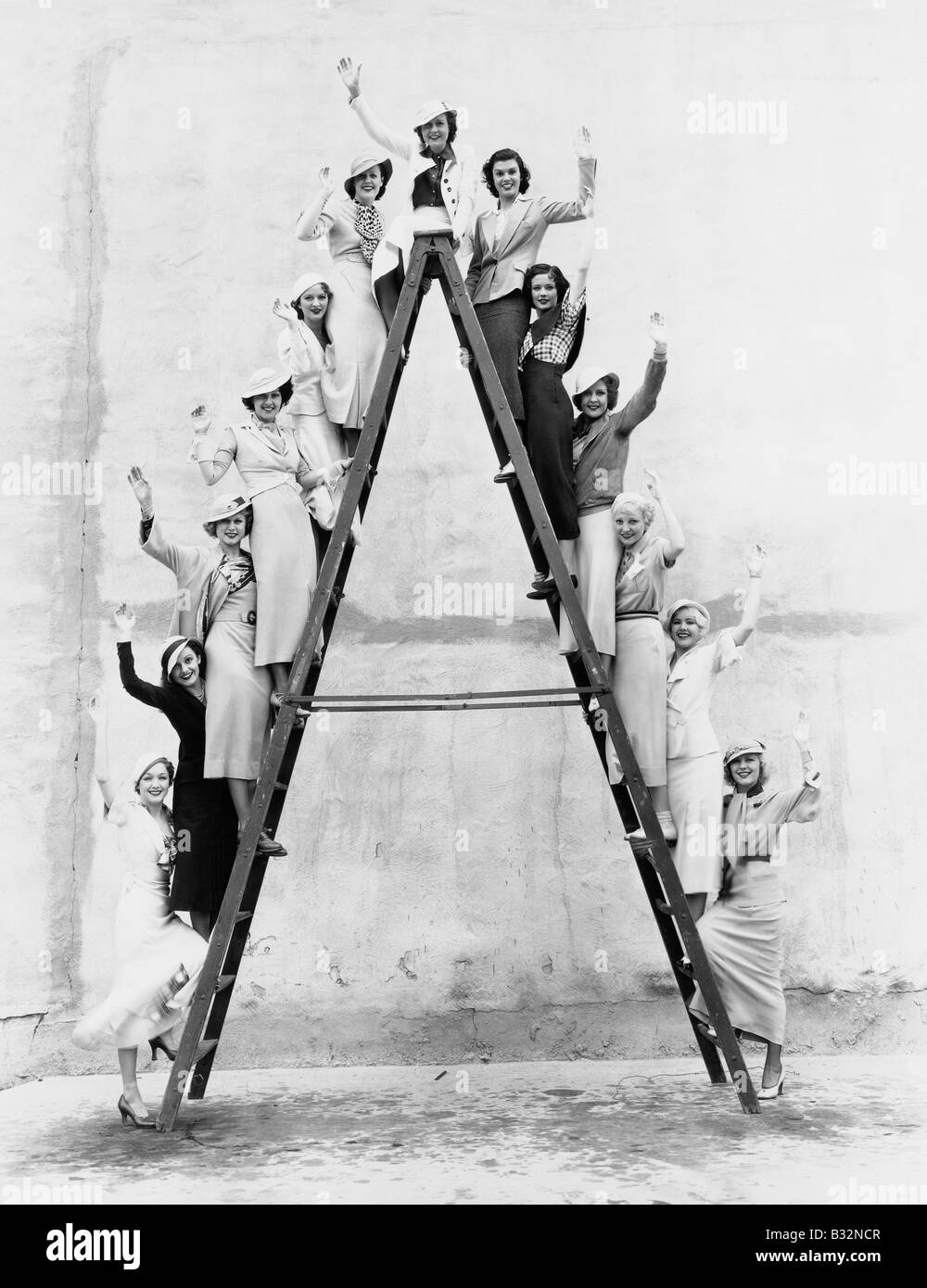 Gruppe von Frauen auf hohen Leiter Stockfoto